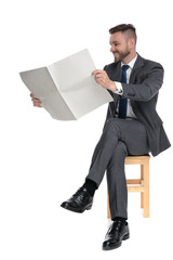 Canvas Print - happy young businessman reading newspaper and smiling