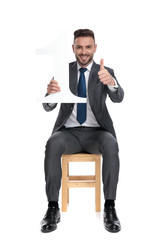 Canvas Print - happy young businessman holding number one sign