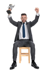 Canvas Print - happy businessman holding trophy and celebrating victory