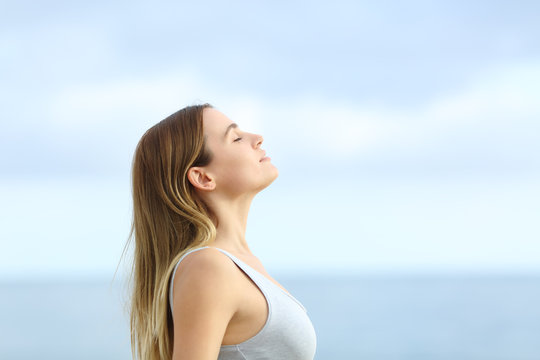 profile of relaxed girl breathing fresh air on the beach