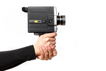 Wall Mural - Female hand holding old style 8 mm movie camera on a white background