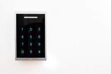 Keypad Electronic Lock Side View. Lock With Black Glossy Front Pane And Blue Dials Placed On White Wall. Copy Space For Text.