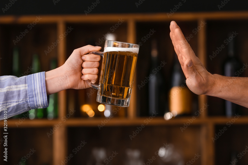 Man refusing to drink beer in bar. Concept of alcoholism