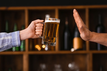 Wall Mural - Man refusing to drink beer in bar. Concept of alcoholism