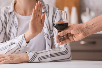 Woman refusing to drink wine at home. Concept of alcoholism