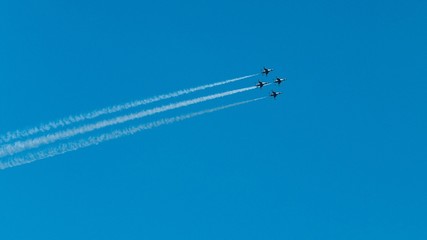 Sticker - Aircraft flying and doing aerobatic demonstrations with trails of smoke against a blue sky