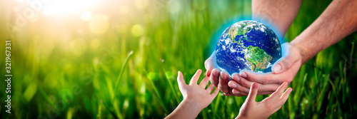 Fotomural Hands Of Man Giving Earth To Child - Protect The Environment For Future Generati
