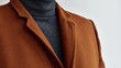 Close up of mens fashionable brown woolen coat combined with grey sweater.  Selective focus.
