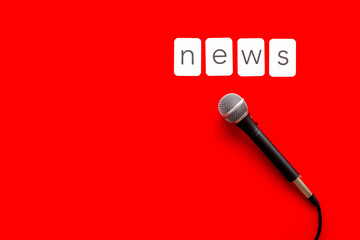 Breaking news concept. Microphone on red background top-down copy space