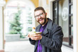 © satura_ - Junk food, eating and lifestyle concept - young man with meal eats on city street.