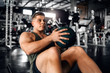 © JonoErasmus - Young attractive muscular gen z athlete doing weighted ball abs exercises