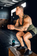 © JonoErasmus - Young attractive muscular gen z athlete doing jump box squats