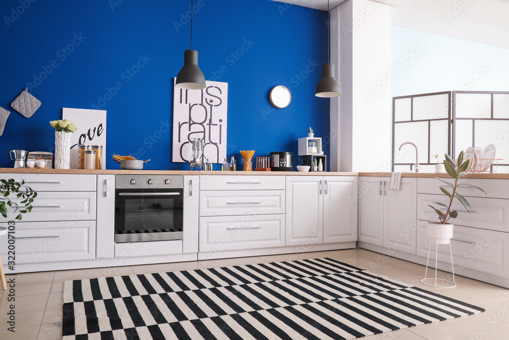 Interior of modern kitchen with blue wall