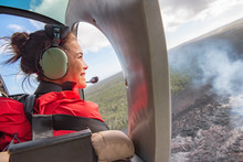 Helicopter Doors Off Ride Adventure Travel Asian Woman Tourist Happy Looking At Landscape Of Volcanic Eruption Above Volcano Fumes In Big Island, Hawaii.