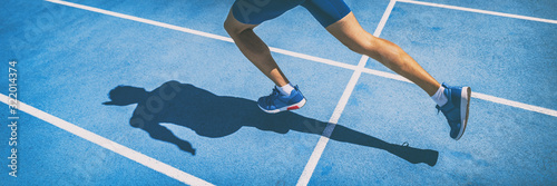 Fotomural Sprinting man runner sprinter athlete running shoes and legs on track and field lane run race competing fast panoramic banner background