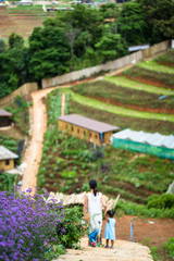 Wall Mural - Mother and daughter walking at flower garden.