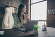 Profile side view portrait of her she nice attractive cheerful cheery trendy successful lady freelancer sitting in chair drinking tea at modern industrial brick loft interior style work place station