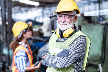 ndustrial Engineers in Hard Hats.Work at the Heavy Industry Manufacturing Factory.ndustrial worker indoors in factory.aged man working in an industrial factory.