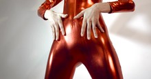 Detail  Close Up Shot Of The Hips Of A Very Slender And Thin Girl In A Tight  Fitting Shiny Red Zentai Suit, Unzippering With Manicure. Isolated On  White Studio Background. 4k 50 Fps Slow Motion