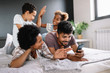 © NDABCREATIVITY - Parents with children enjoying playing games or entertaining using mobile apps on phone at home