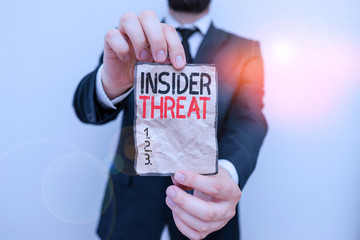 Wall Mural - Text sign showing Insider Threat. Business photo showcasing security threat that originates from within the organization Male human wear formal work suit office look hold notepaper sheet use hand