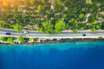 Wall Mural - aerial view of road in beautiful green forest and sea coast at sunset in spring. colorful landscape 