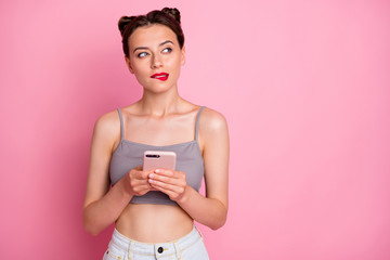 Sticker - Portrait of minded girl use smartphone want type social media message look copyspace feel unaware think thoughts unsure bite lips wear grey tank-top isolated pink color background