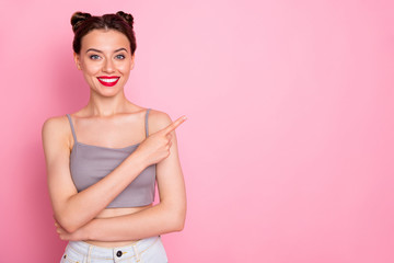 Wall Mural - Photo of pretty youngster lady pretty buns red pomade indicating finger empty space advising best shopping prices wear casual grey short top isolated pink color background