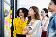 © saksit - Group of Asian business people meeting at modern office .Young creative team use post it notes to share idea sticky note on glass wall. and working design planning and Brainstorming focus concept.