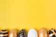 Flat Lay of Golden Easter Eggs on yellow background. Minimal easter concept. Happy Easter card with copy space for text. Top view. Horizontal.