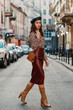 © Victoria Fox - Outdoor full body fashion portrait of elegant luxury woman wearing leopard print blouse, faux leather dark red skirt, beret, holding small brown classic handbag, walking in street of European city