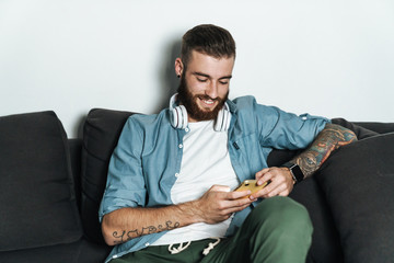 attractive young bearded man relaxing on a couch at home