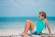 Little Girl Listening To Music On Headphones On Caribbean Beach