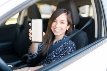 Happy Woman With Smartphone In Car