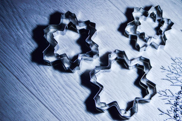 Metal molds for biscuits of various shapes on a gray background with New Year's garland