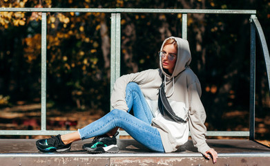 Wall Mural - Stylish model girl at skate park in glasses with waist bag