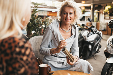 Wall Mural - Woman is reading Tarot cards on the table in cafe