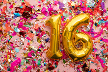 Number 16 Gold Birthday Celebration Balloon On A Confetti Glitter Background