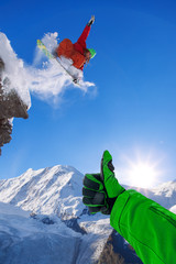 Wall Mural - Snowboarder jumping against blue sky in high mountains