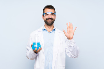 Wall Mural - Young scientific holding laboratory flask over isolated background counting five with fingers