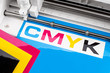 production making CMYK sticker with plotter cutting machine on cyan blue colored vinyl film. Advertising Industry diy design concept background.