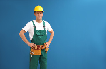 Poster - Handsome carpenter with tool belt on blue background. Space for text