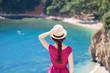 © Mary Anlens - Young graceful woman at sea beach in summer vacation. Rear view of girl traveler in straw hat. Concept of travel, femininity, solo female tourism, holiday, adventure. Lady looking at ocean view.
