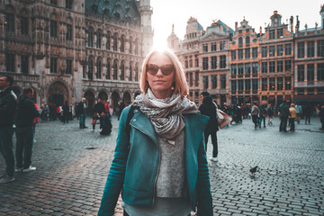 Wall Mural - Woman stands in the square Grand Place in Brussels, Belgium at sunset.