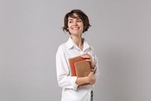 Smiling Young Business Woman In White Shirt Posing Isolated On Grey Background Studio Portrait. Achievement Career Wealth Business Concept. Mock Up Copy Space. Holding Books, Notebooks, Looking Aside.