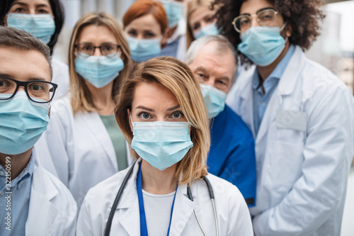 Fotografía Group of doctors with face masks looking at camera, corona virus concept
