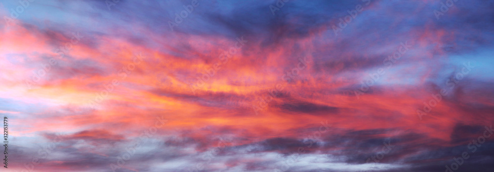 The bright fiery colors of sunset in the mountains are a beautiful sight. Red clouds can be used as background in digital processing. - obrazy, fototapety, plakaty 