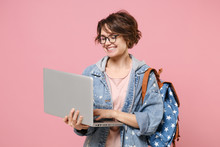 Smiling Young Woman Student In Denim Clothes Glasses Backpack Isolated On Pastel Pink Background. Education In High School University College Concept. Mock Up Copy Space. Work On Laptop Pc Computer.