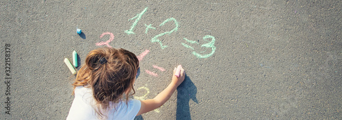 The child decides grunts on the asphalt. Selective focus. Tableau sur Toile