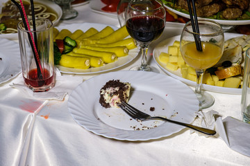 The leftover food and dirty dishes on the restaurant table. Scraps left over after the party.